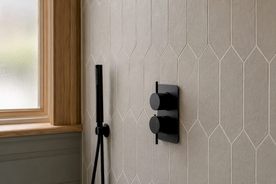 Close-up of porcelain tiles and shower valve