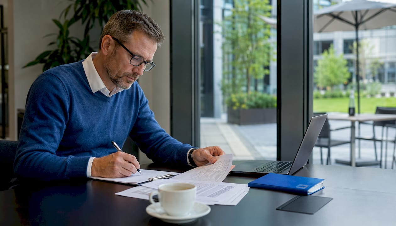 Ein Mitarbeiter überprüft im Büro aktuelle Energiecontracting-Verträge.