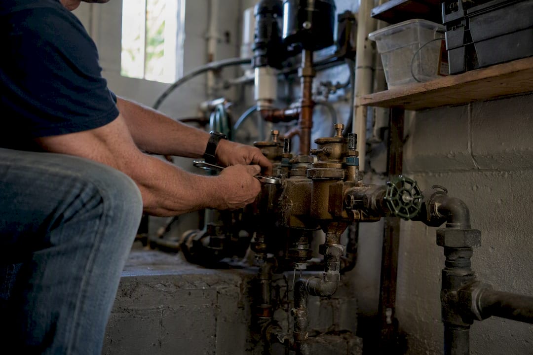 Hands repairing backflow device indoors