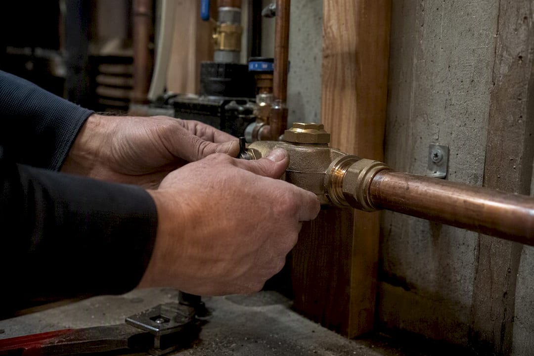 Plumber installing isolation backflow device inside building