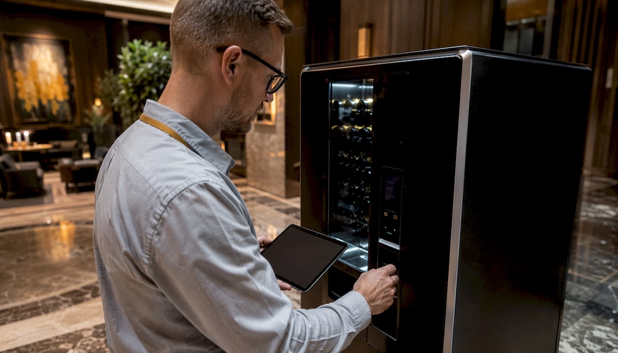 Im Hotel wird der Getränkeautomat vom Techniker gewartet.