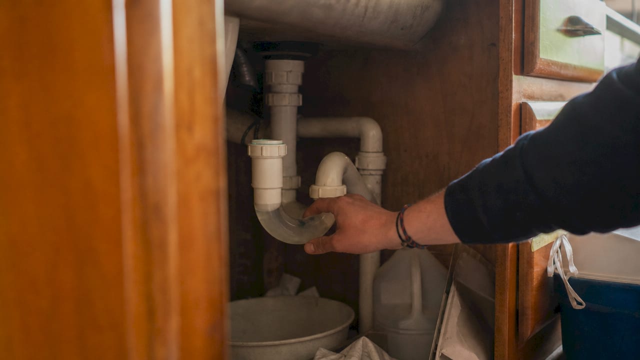 Close-up of trap seal plumbing pipe under sink