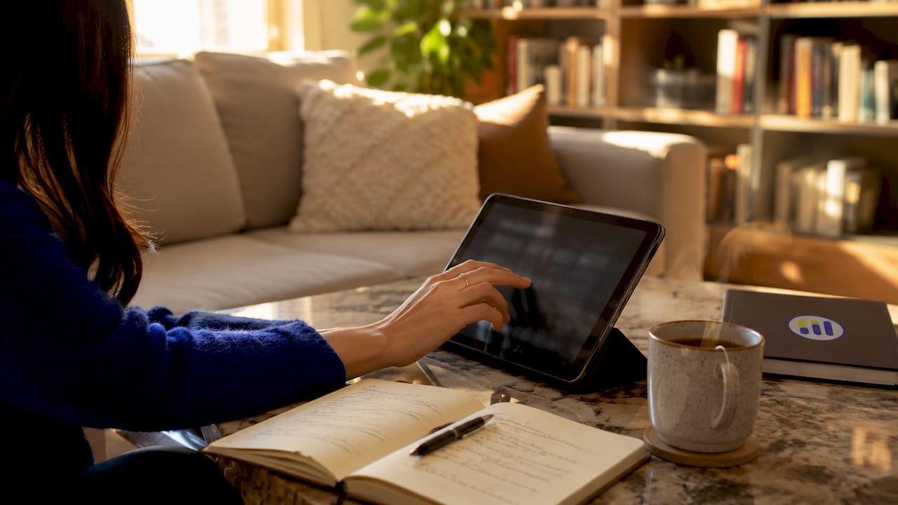 Hand using stock screener tablet in café