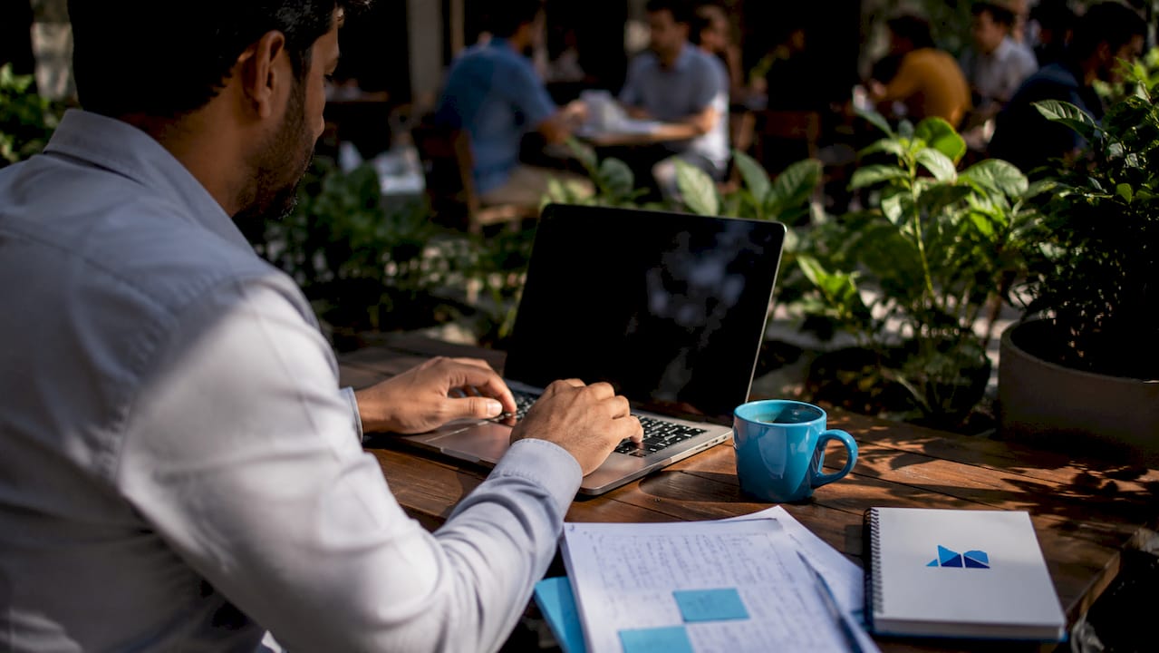 Hands typing on laptop in co-working space