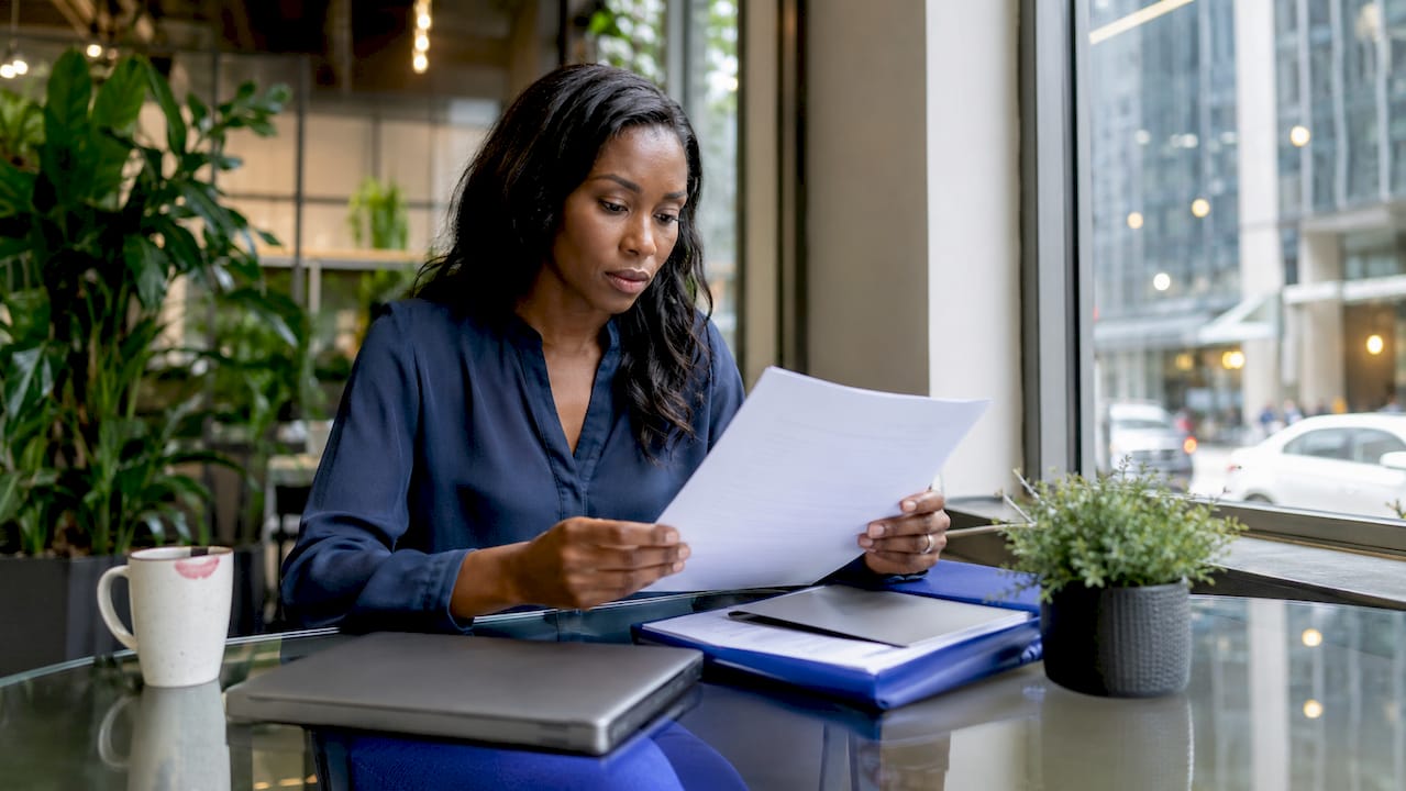 Businesswoman reviewing ethics report at desk