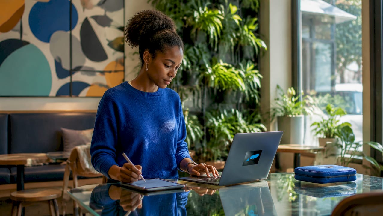 Woman working with laptop and tablet in co-working space