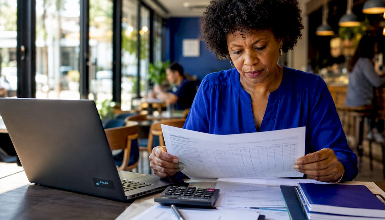 Woman reviewing business asset register paper
