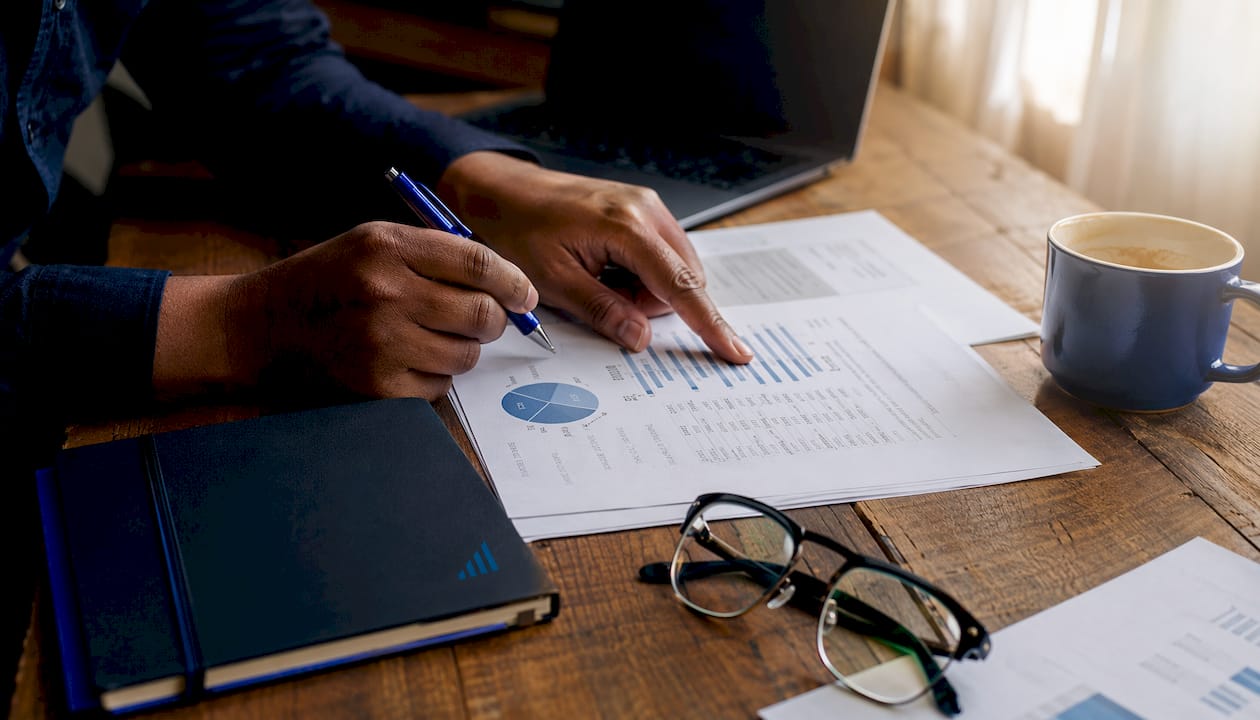 Hands reconciling SOA tax documents at office desk