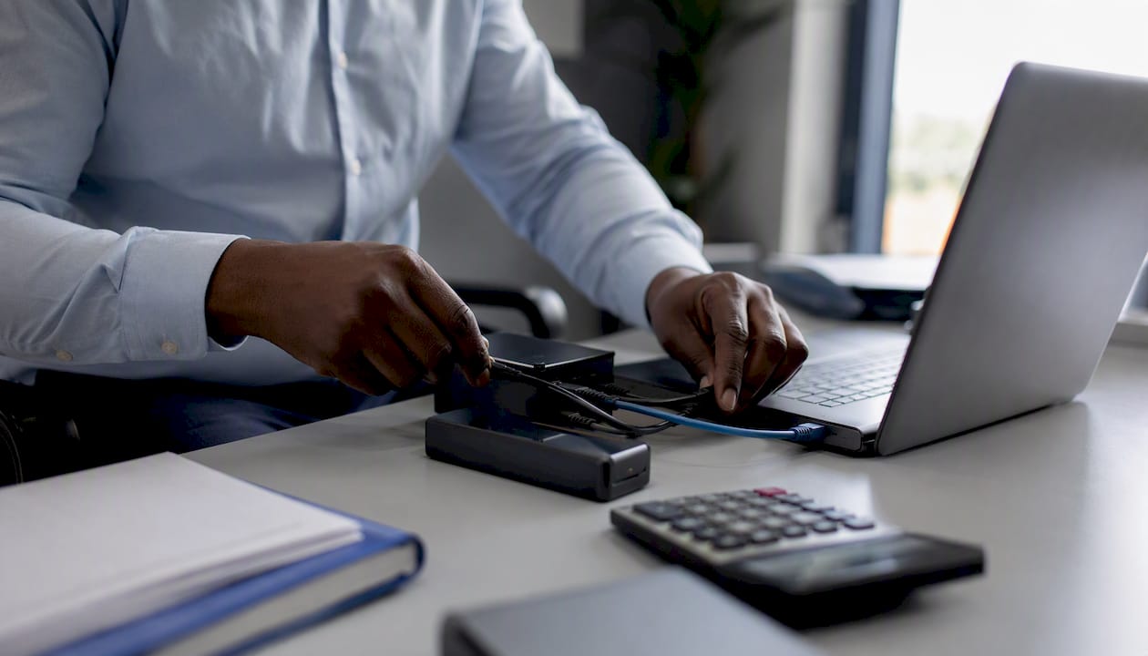 Hands connecting cloud accounting cables on desk