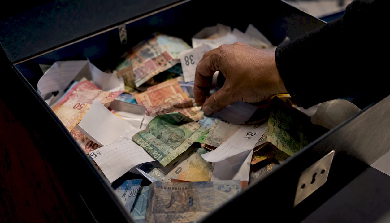 Disorganized petty cash box with vouchers and cash