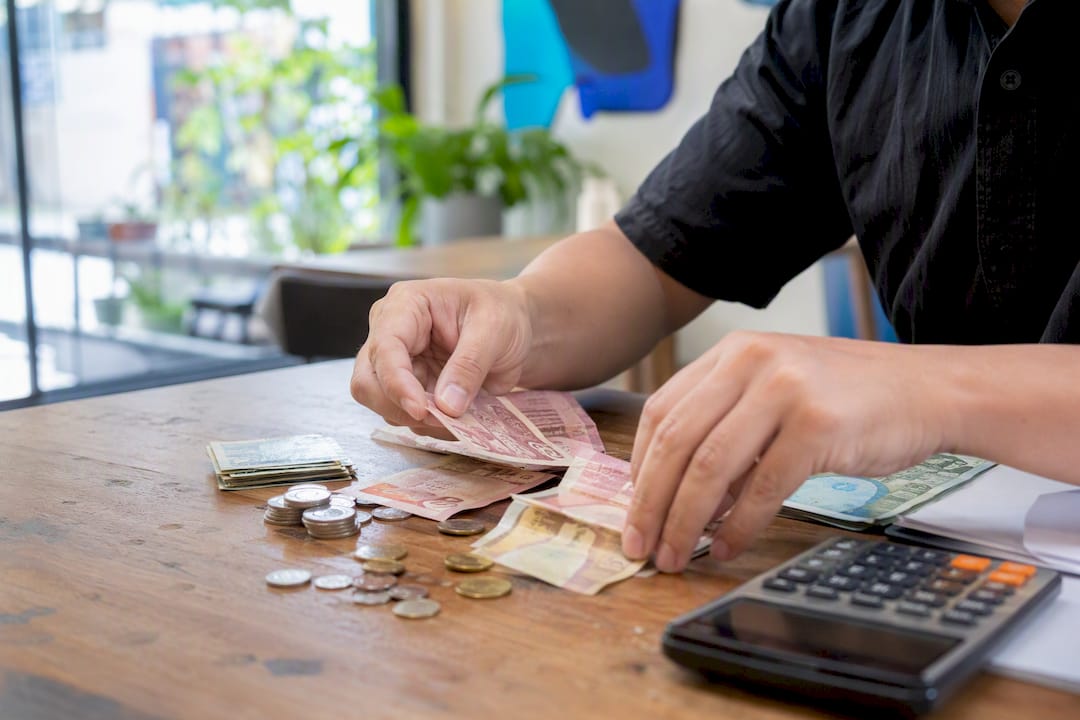 Hands sorting cash receipts on desk