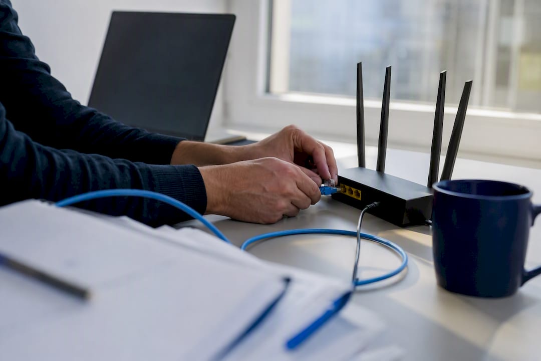 hands connecting network cable on office desk