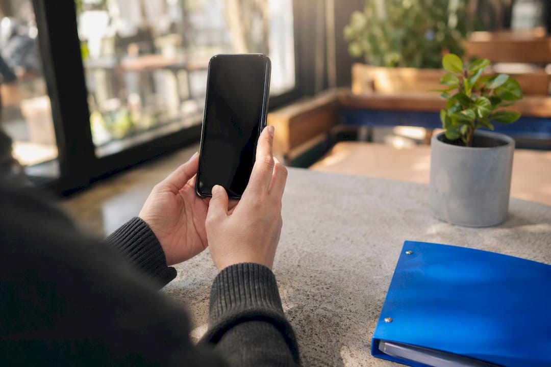 Hands holding smartphone recording vertical video
