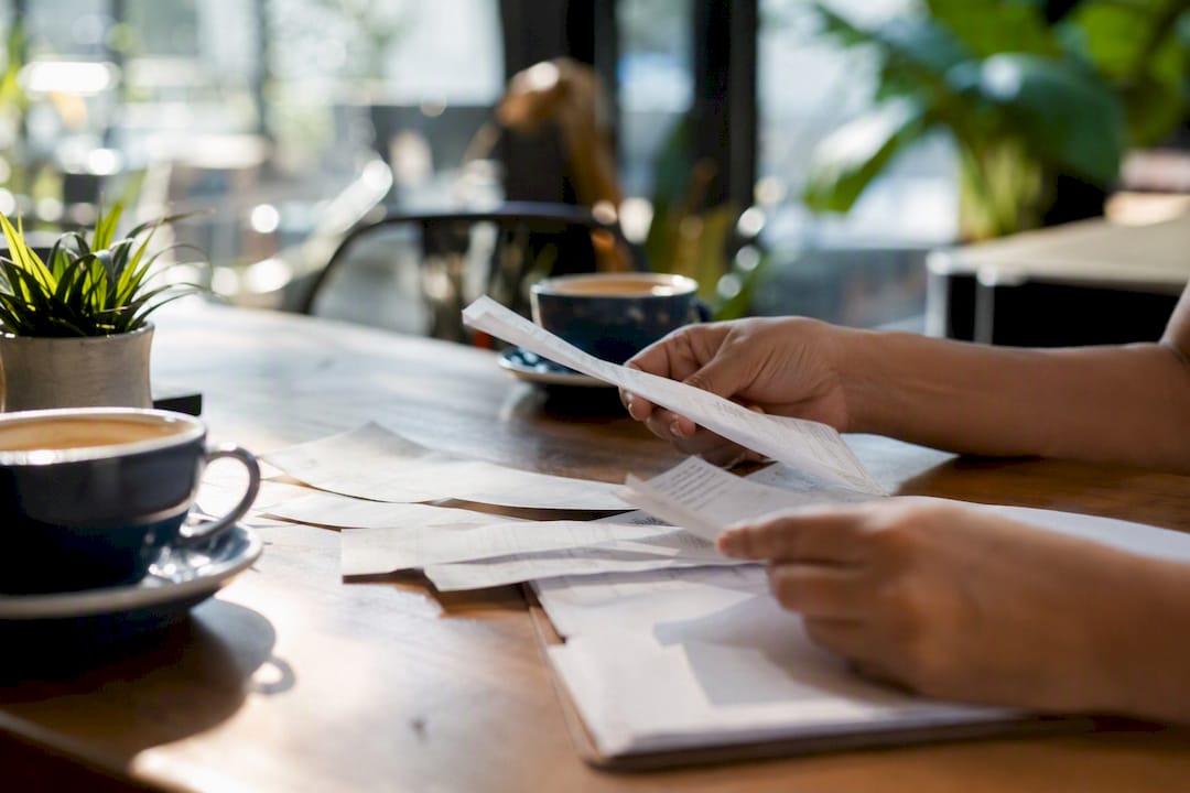 Hands arranging accounting documents on desk