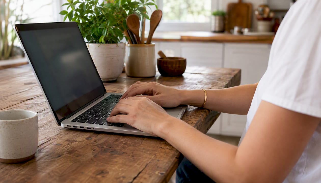 Hands typing on laptop in restaurant setting