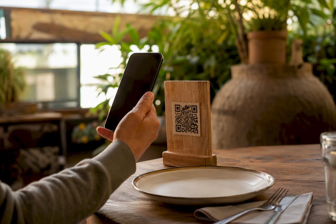 Hand scanning QR code on restaurant table
