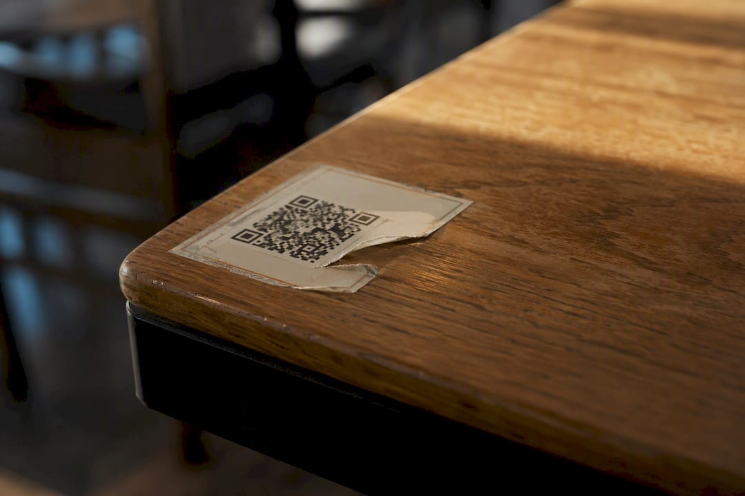 Peeling QR menu sticker indicating tampering