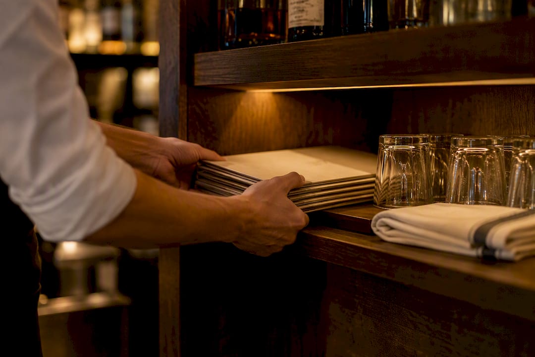 Paper menus stored behind a bar