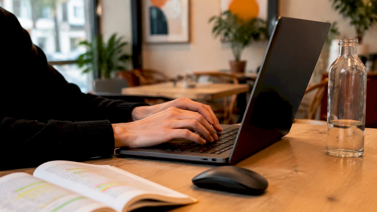 Zoom sur des mains en train de taper sur le clavier d’un ordinateur portable.