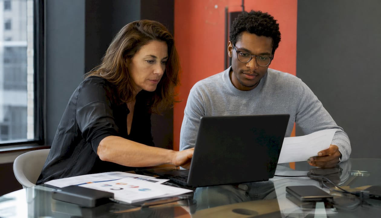 Deux spécialistes en informatique travaillent ensemble pour analyser en profondeur les performances d’un ordinateur.