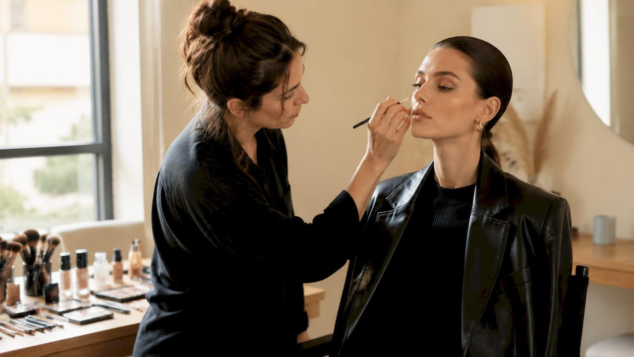 La make-up artist perfeziona il trucco editoriale direttamente in studio, curando ogni dettaglio per ottenere un risultato impeccabile davanti alla fotocamera.
