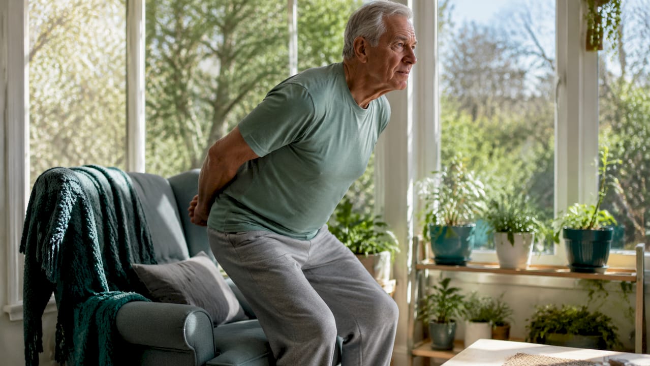 Senior man doing chair sit-to-stand exercise