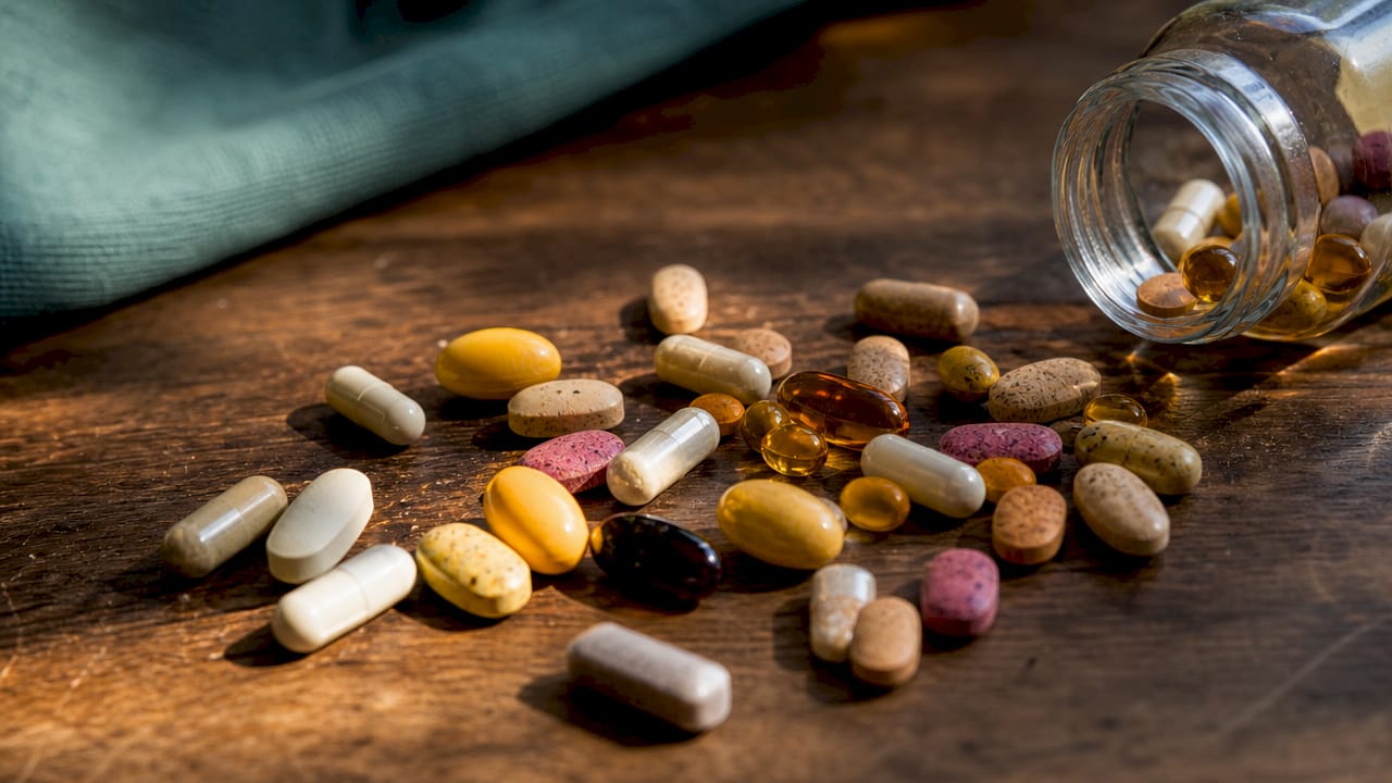 Assorted multivitamin pills on white surface  