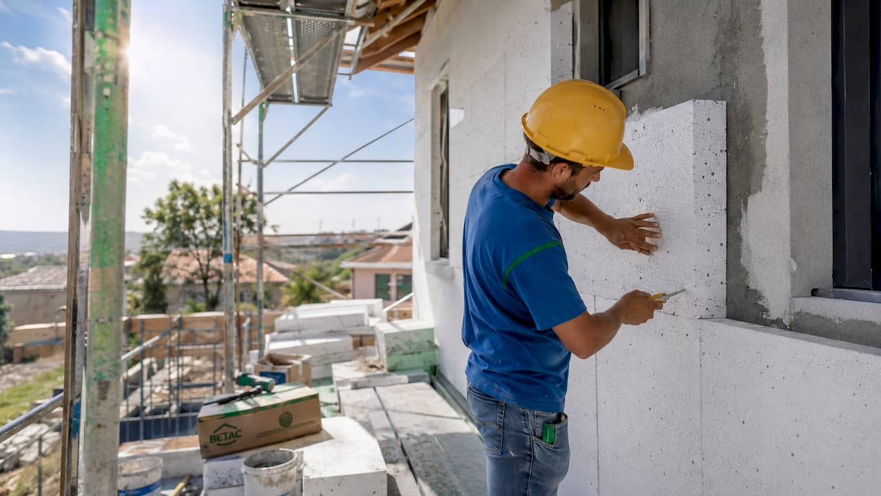 Técnico a aplicar painéis de poliestireno ignífugo no exterior
