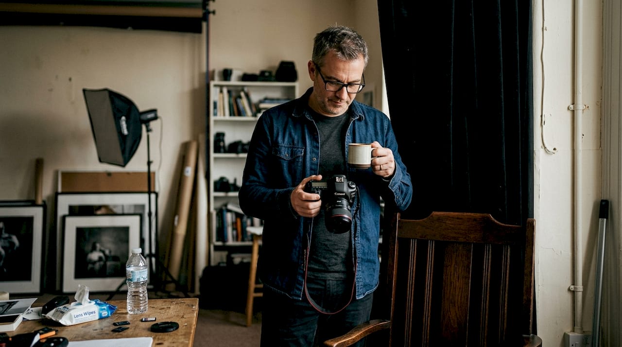 Hombre revisando fotografías en un estudio con fondo oscuro
