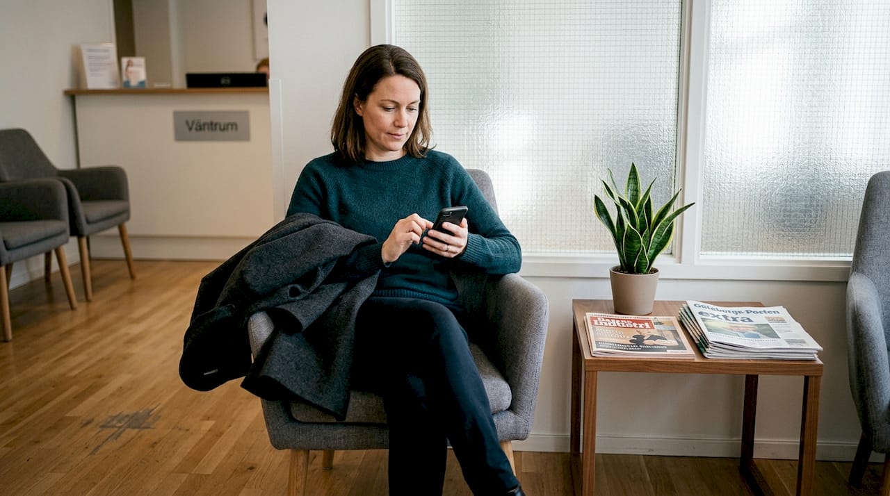 En person sitter i väntrummet på en skönhetsklinik och väntar på sin behandling.
