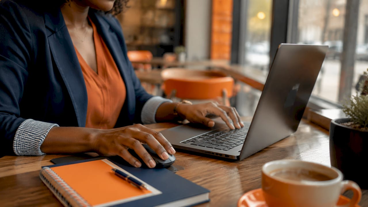 Hands typing on laptop in warehouse office