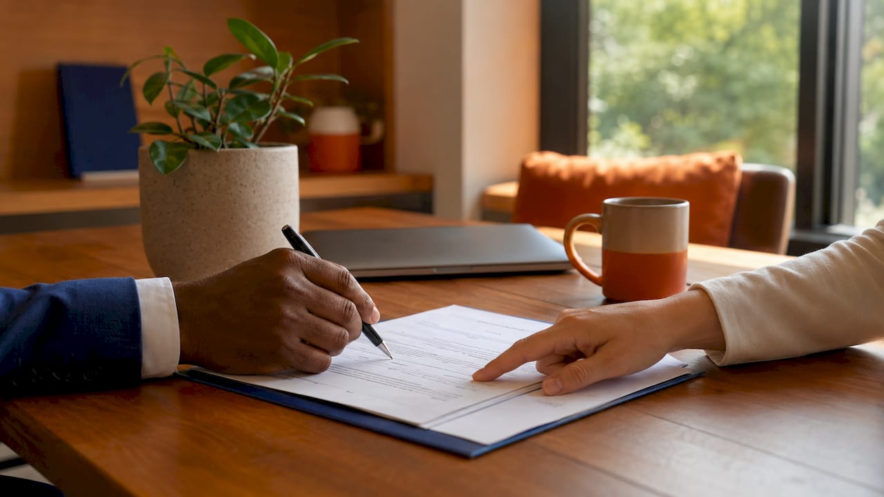 Hands discussing lease contract over table