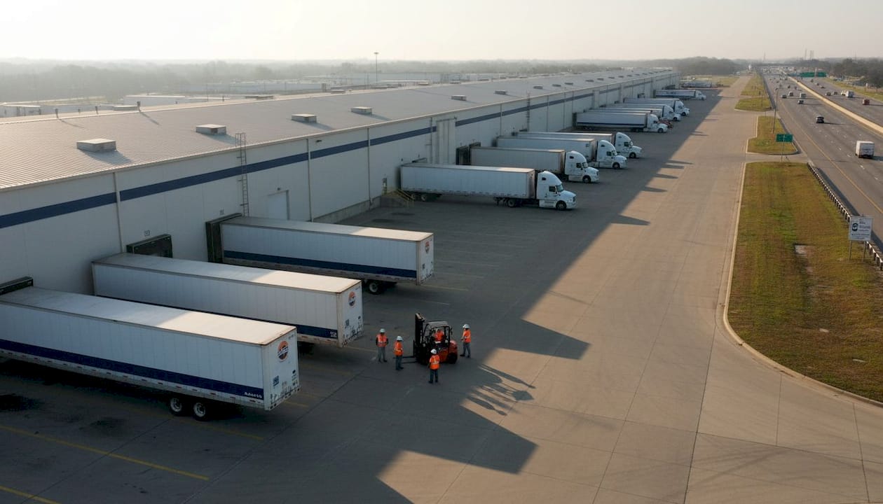 Overhead industrial warehouse near highway with trucks