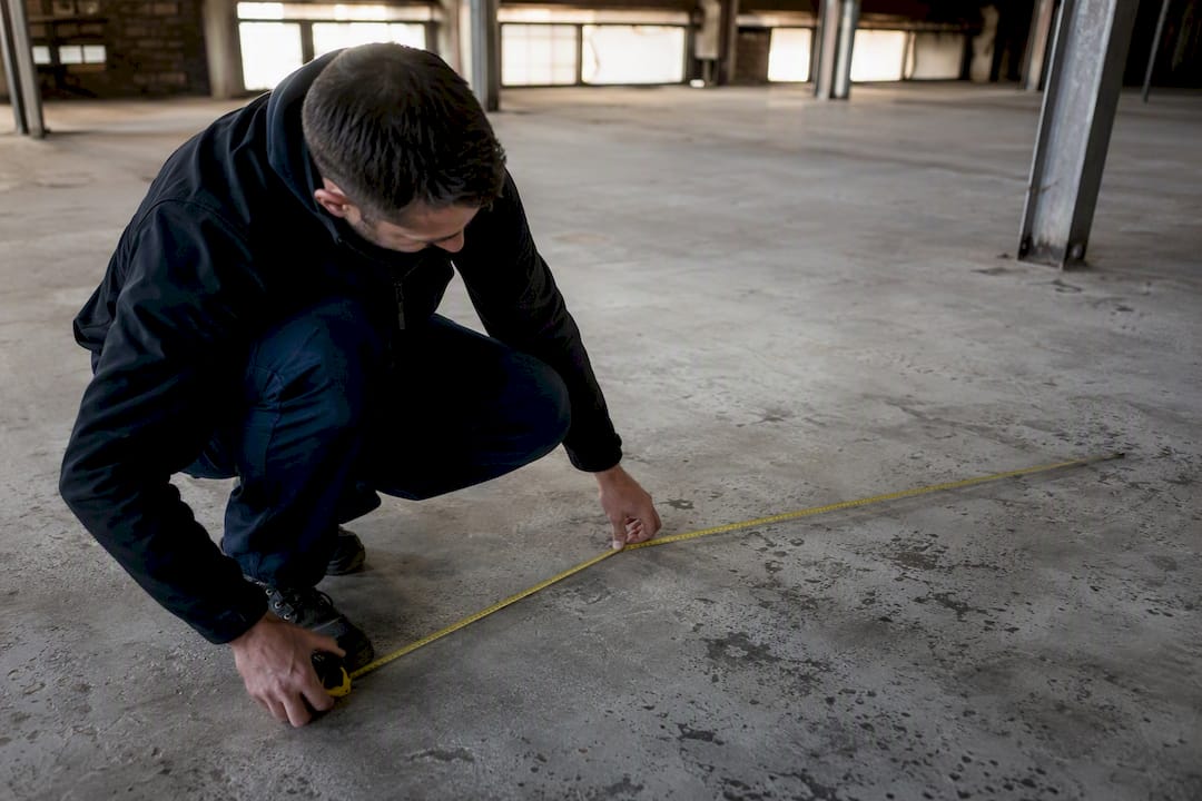 Tenant measuring warehouse space with tape measure