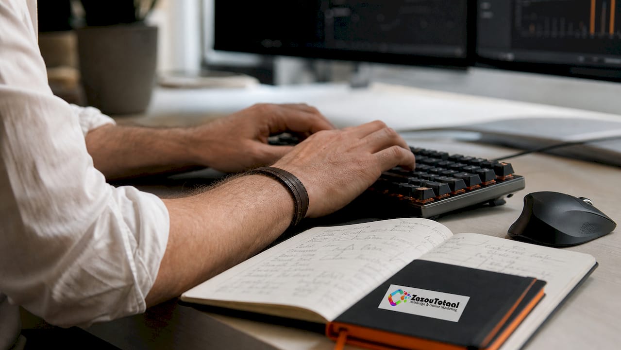 De handen van een IT-specialist vliegen over het toetsenbord terwijl hij werkt aan het optimaliseren van een website.