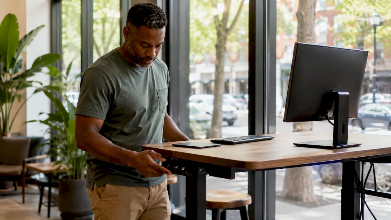 Man adjusting motorized smart standing desk