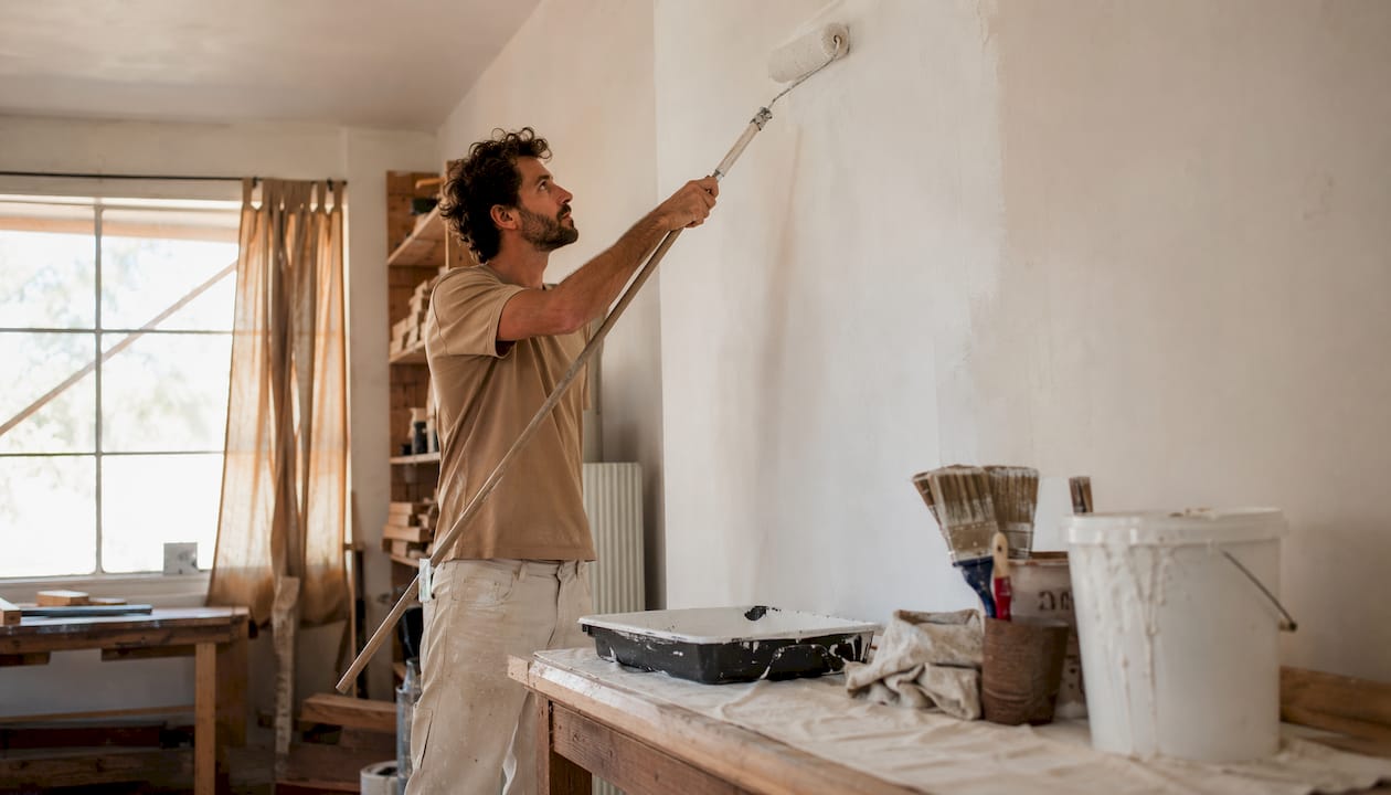 Homeowner applying primer to wall