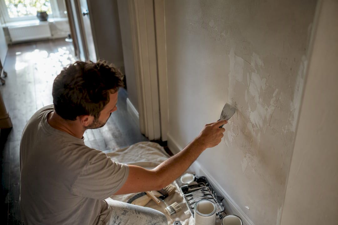 Painter filling cracks on interior wall