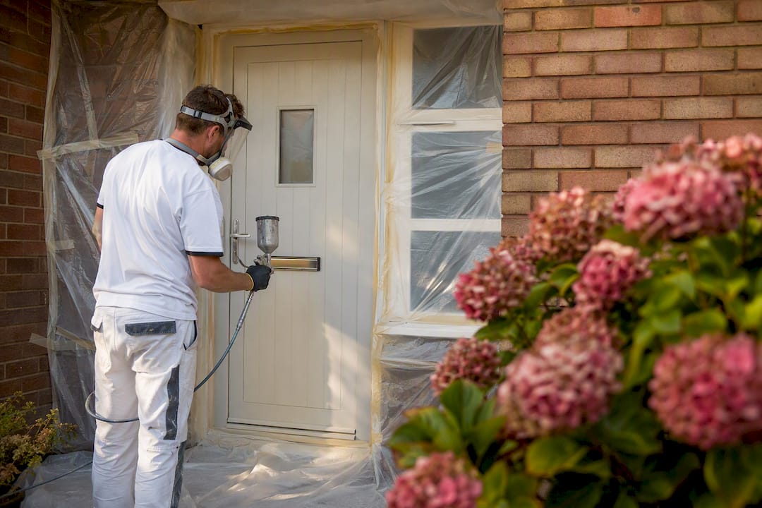 Painter spraying uPVC door finish