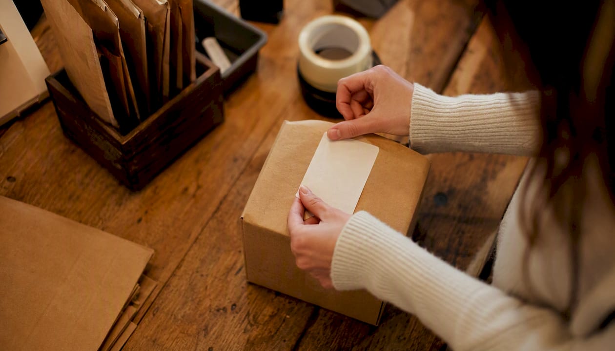 Hands applying label to food packaging