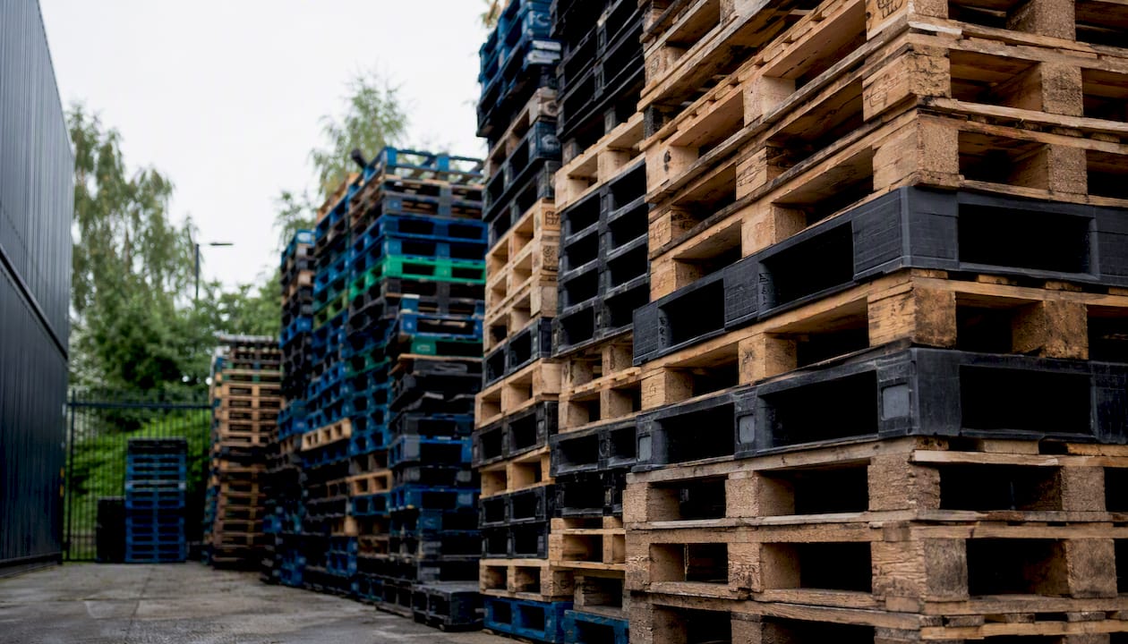 Stacked pooled pallets in warehouse