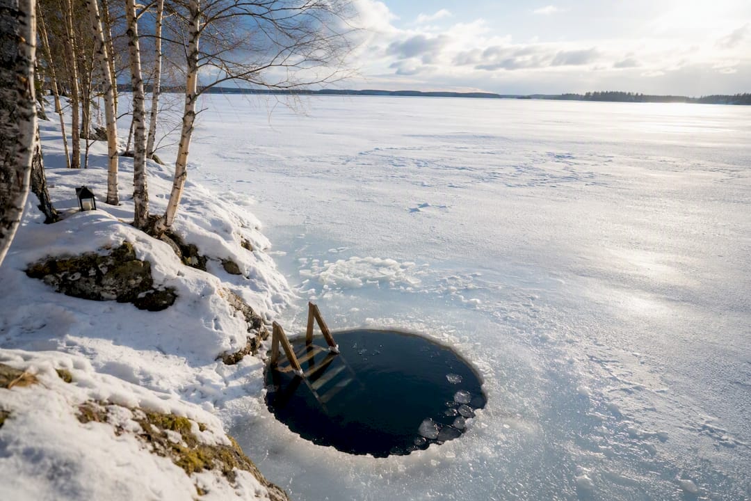 Ice swimming hole with ladder on frozen lake