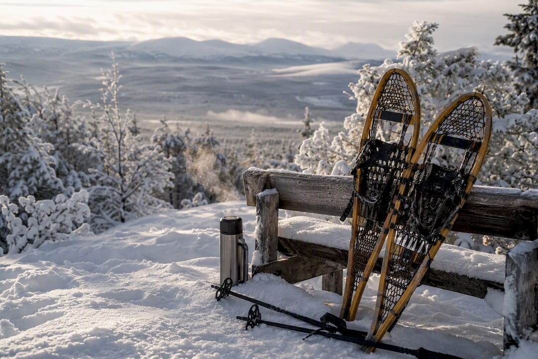 Technical snowshoes, poles, and thermos outdoors