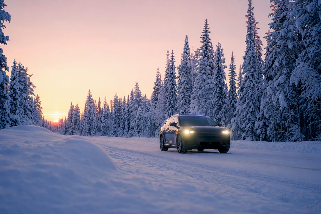 Electric car driving on snowy Lapland road