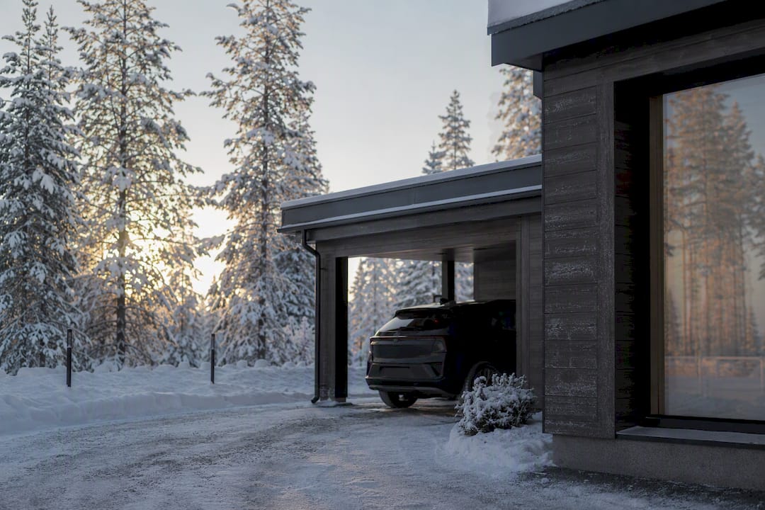 Covered EV parking near snowy cabin at dawn