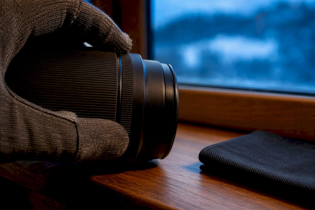 Gloved hand adjusting lens aperture ring