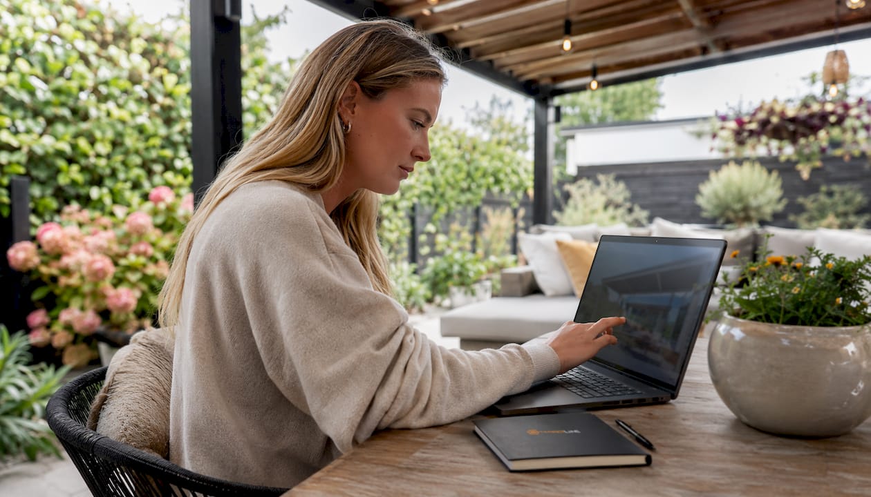 Vrouw ontwerpt haar ideale veranda met behulp van een digitale configurator op haar laptop.