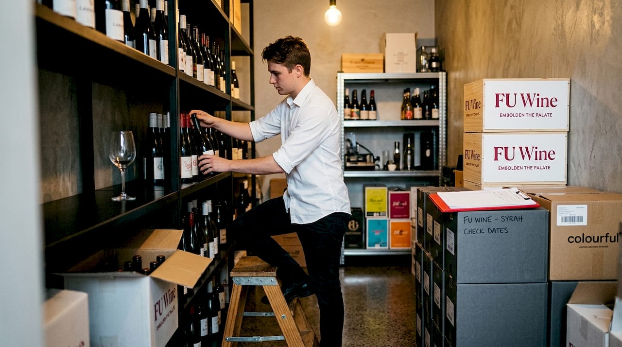 Staff organizing wine bottles in storage room