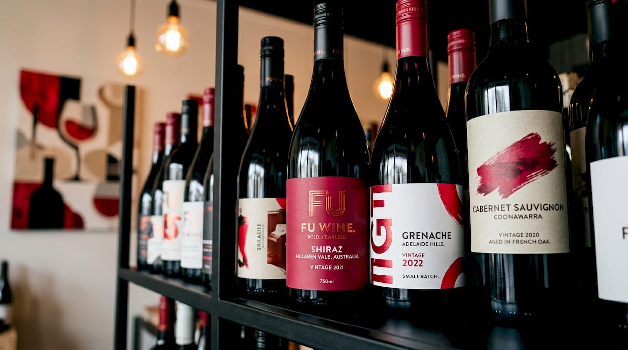 Close-up of varied wine bottle labels on shelf