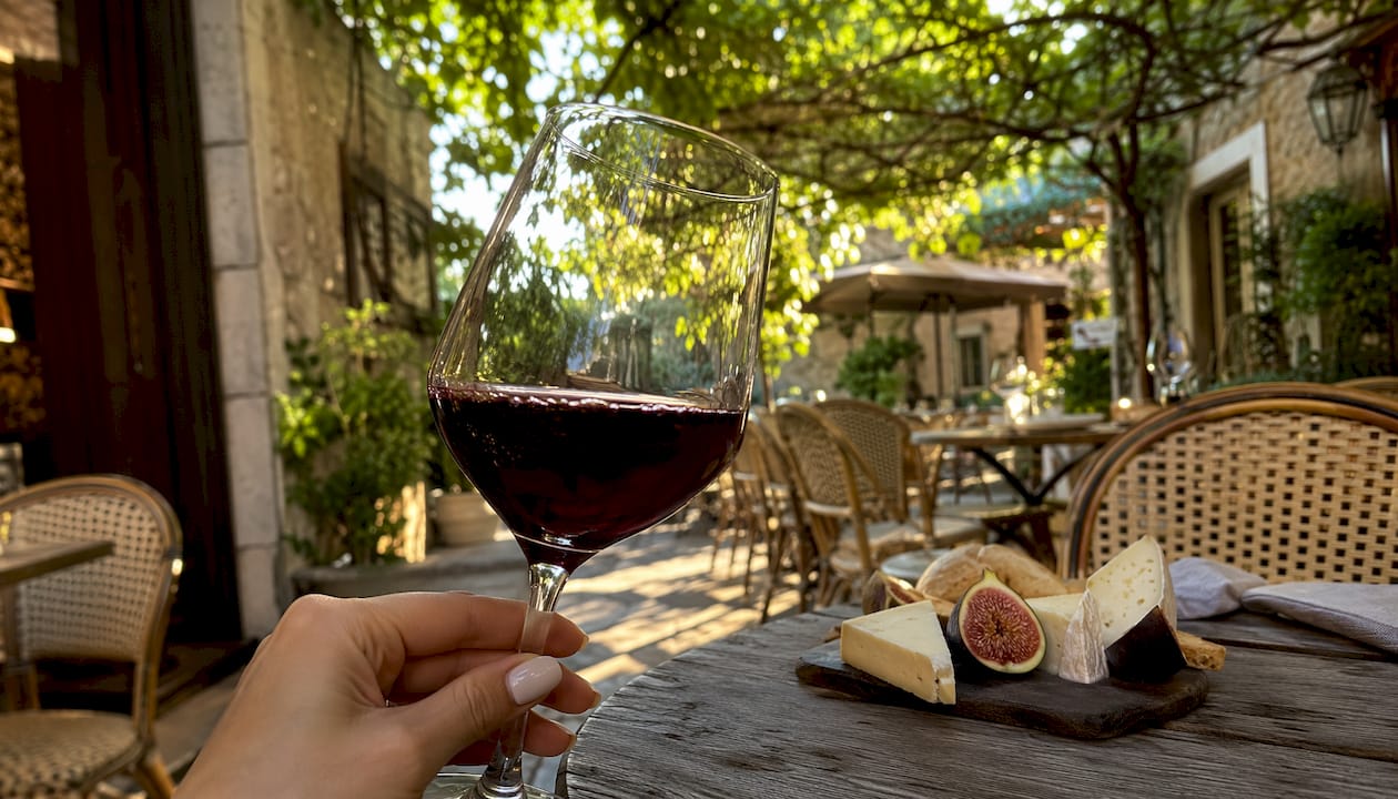 Hand holding glass of smooth Merlot wine